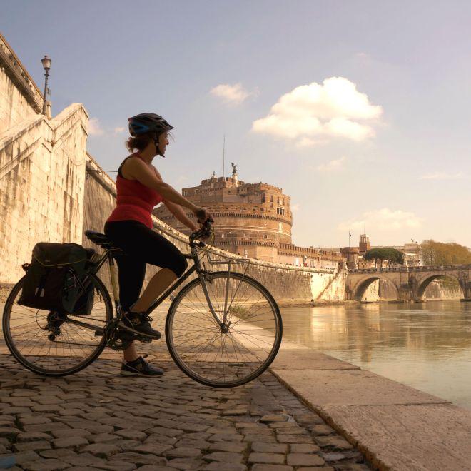 cycling tours womanon bike on river tiber in rome