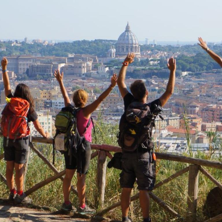 Gruppo di viaggiatori su sentiero osserva centro di Roma