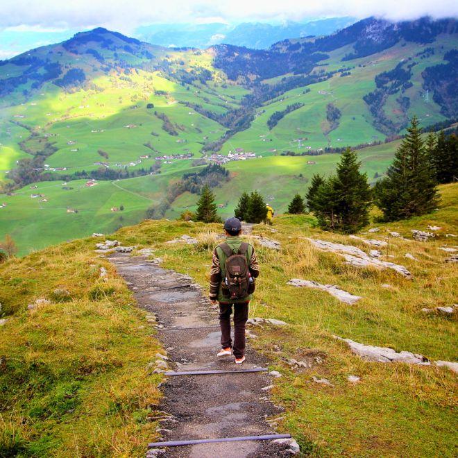 Camminare su un sentiero tra un prato verde e colline