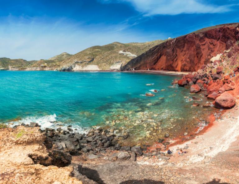 Paesaggio di Spiaggia di Santorini con rocce rosse e mare 