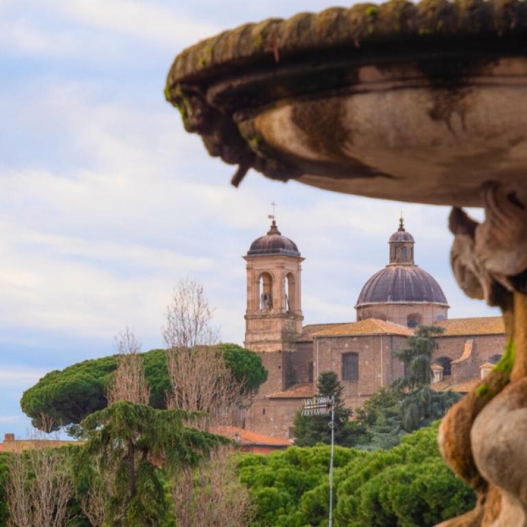 Panoramic view of Viterbo along the Via Francigena Viterbo to Rome with a historic church and fountain in the foreground