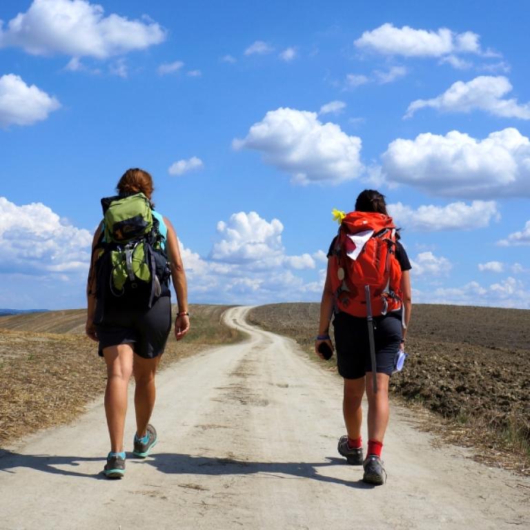 Hikers walking along the Via Francigena Siena Viterbo trail through the Tuscan countryside