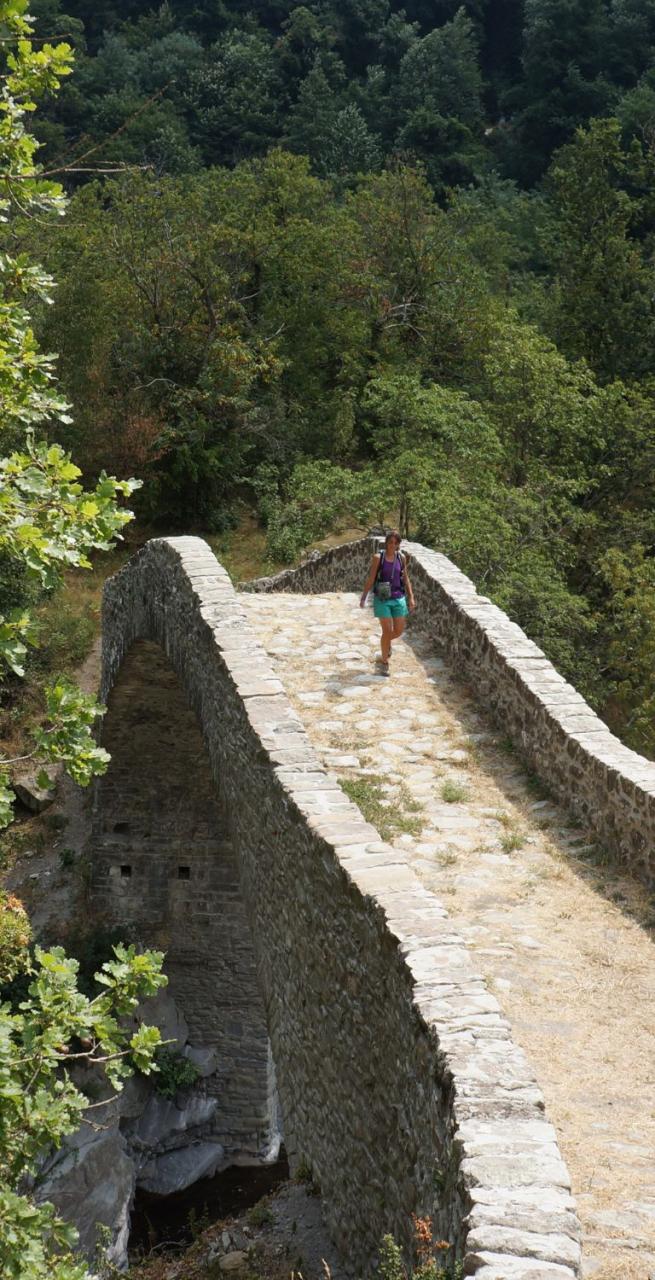 walker on stone bridge on the Fidenza-Pontremoli section of Via Francigena