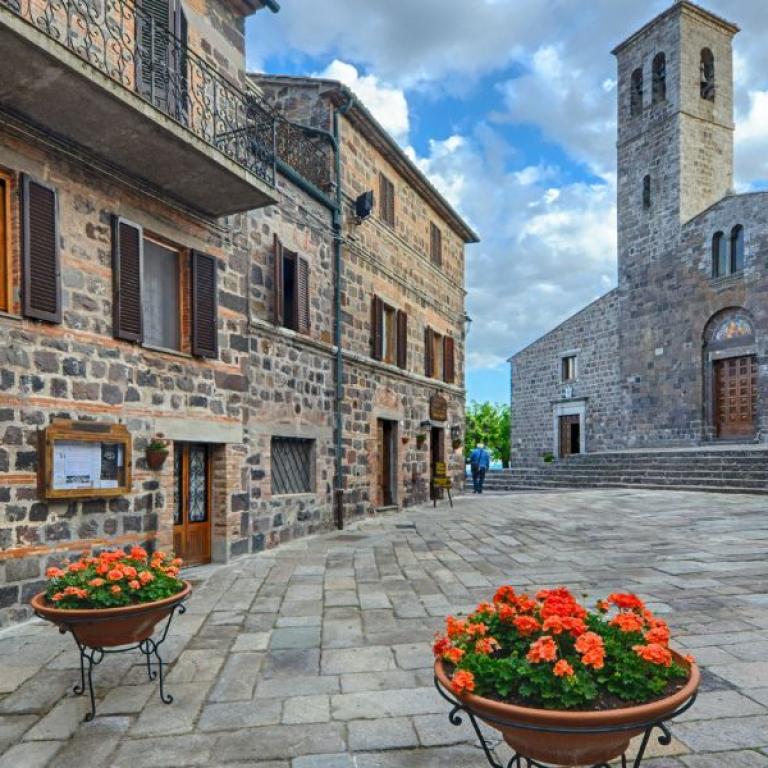 san pietro square in radicofani curch and flowers