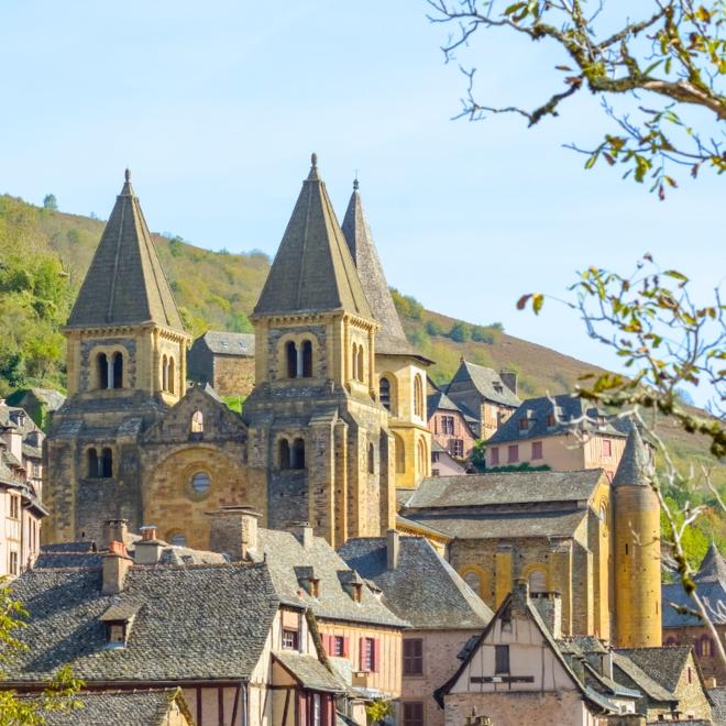 Romanesque church rising above a medieval village, a charming stop on France hiking tours.