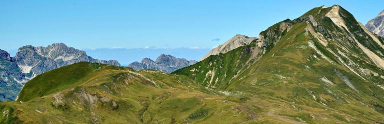 Paisaje alpino amplio en Austria con crestas verdes ideales para senderismo en Austria.