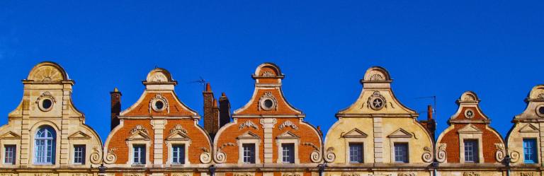 Colorful roofs in Arras under a blue sky 