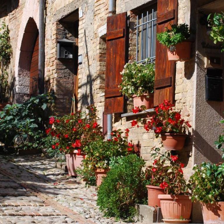 Toscana Umbria stradina pittoresca di paese con fiori 