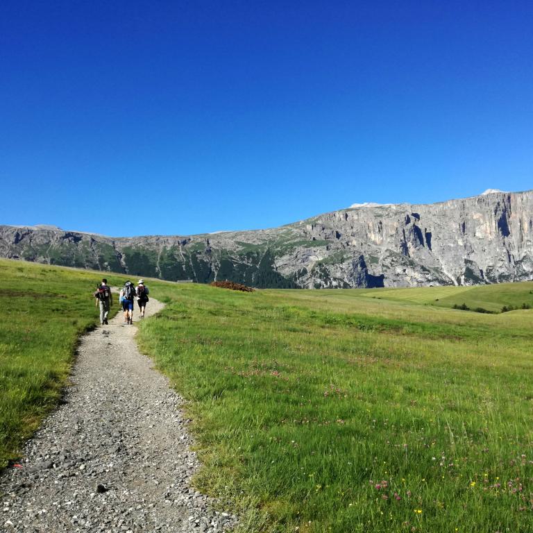 people walking towards massif in the Dolomites