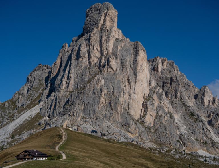 Camino que sube hacia las paredes rocosas del Paso Giau, una de las rutas más espectaculares de senderismo en Italia