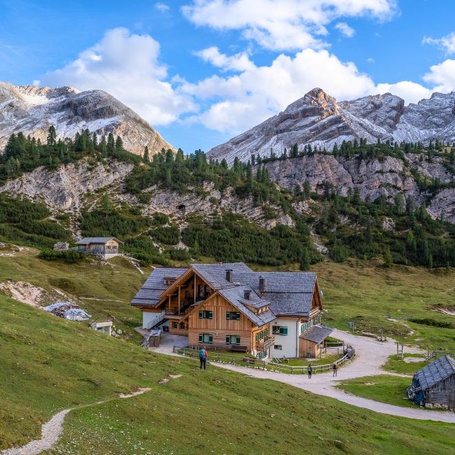 Refugio de montaña rodeado de senderos panorámicos de las Dolomitas, ideal para los amantes del senderismo en Italia