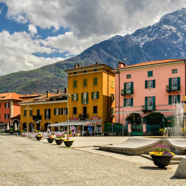 village on lake como with colorful houses mountains in background