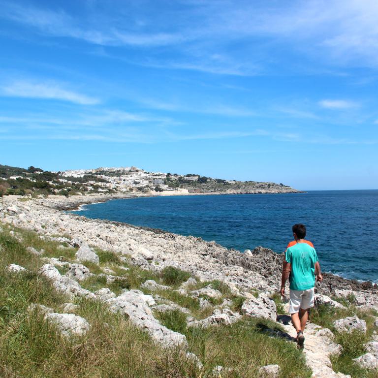 Pebble beach with a man walking in Puglia