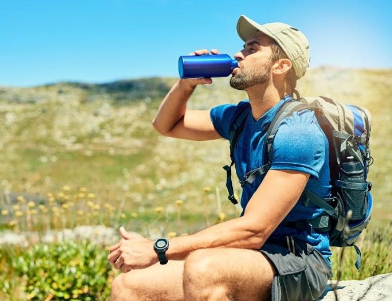 Excursionista bebiendo agua durante una caminata por la naturaleza – viajes a pie por Puglia y Matera