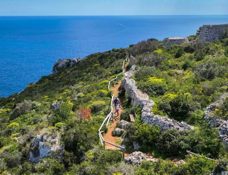 Sendero costero con mar cristalino a lo largo de la Costa de Salento – viajes a pie por Puglia y Matera