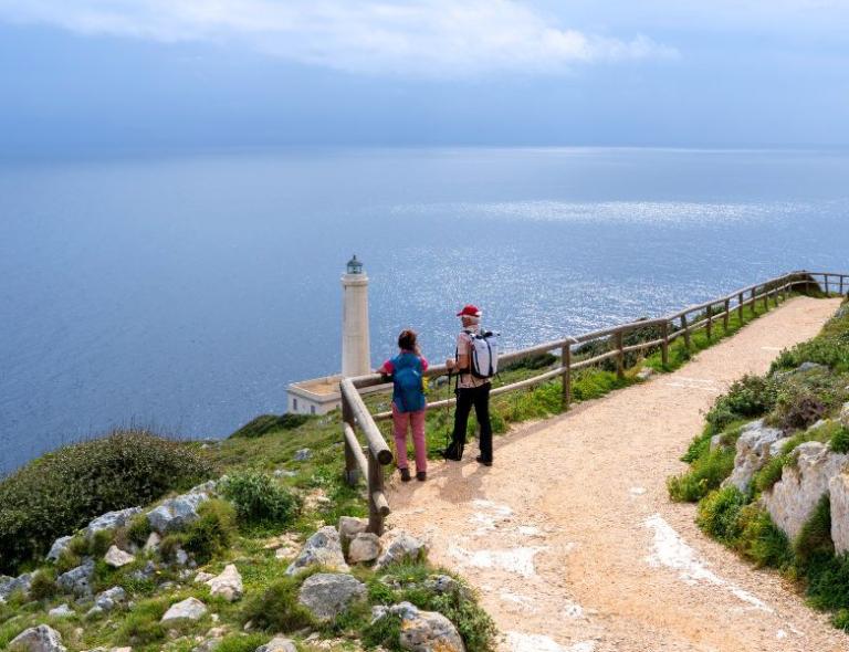 Senderistas caminando hacia el faro de Punta Palascia – viajes a pie por Puglia y Matera
