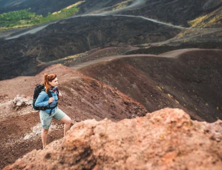 Young woman walking alone on the Etna Volcano Sicily