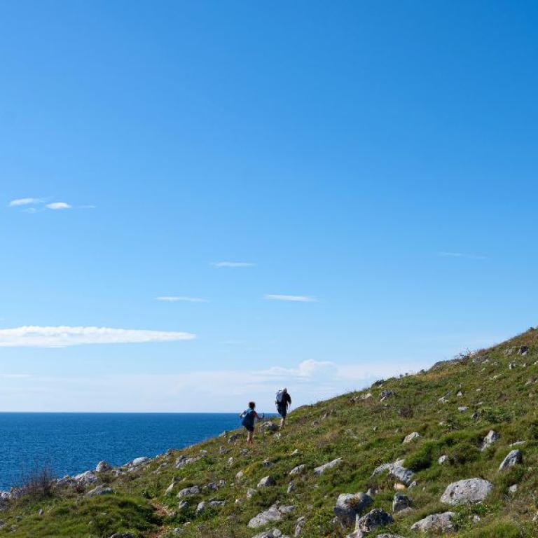 Panoramic coastal cliffs and blue sea views during hiking in Southern Italy