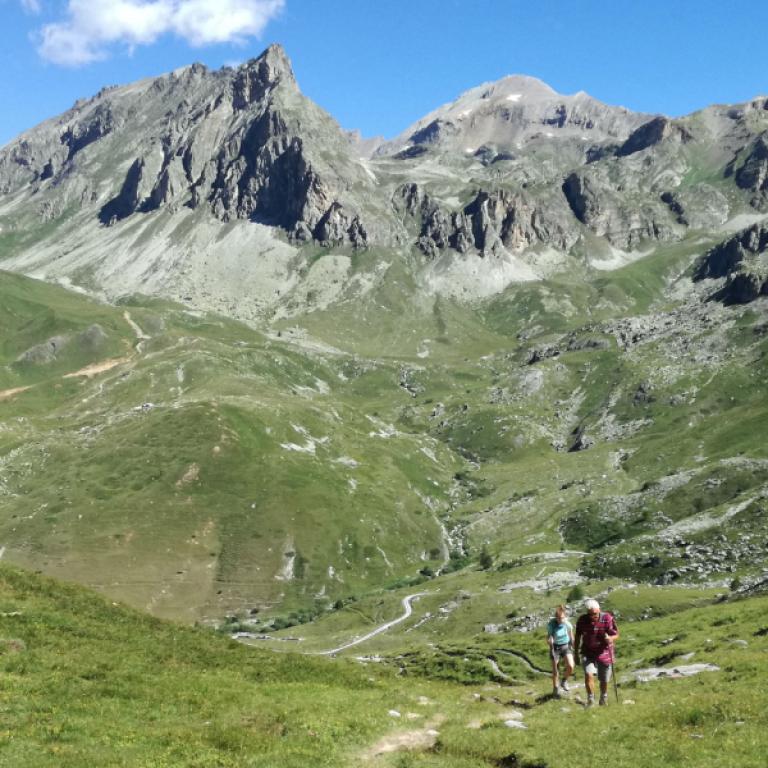 Excursionistas cruzando un sendero panorámico en unas Vacaciones en el Norte de Italia