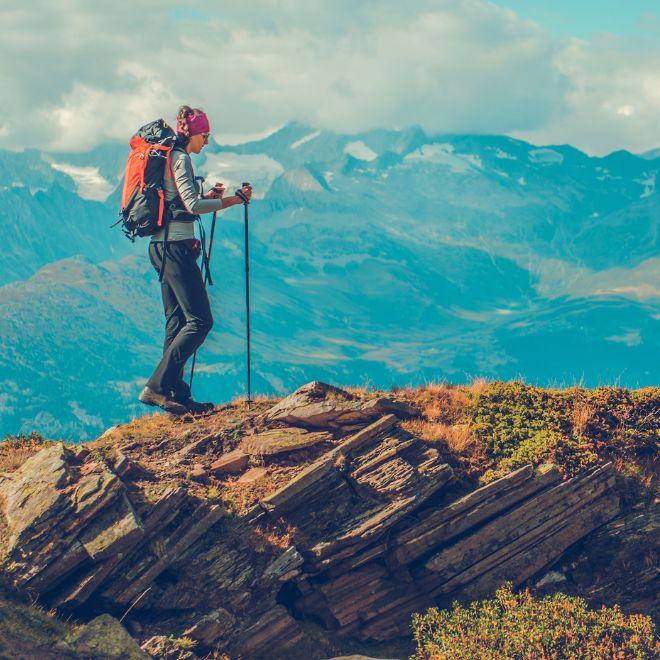 Trips in the peaks mountain hiker with sticks