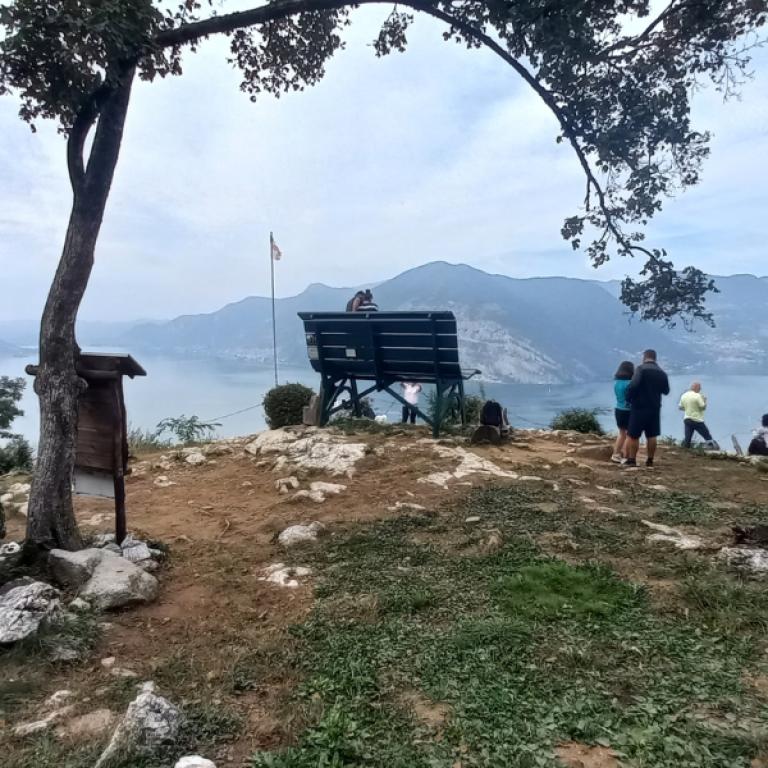 Panchina con vista panoramica sul lago d'iseo durante un cammino intorno al lago