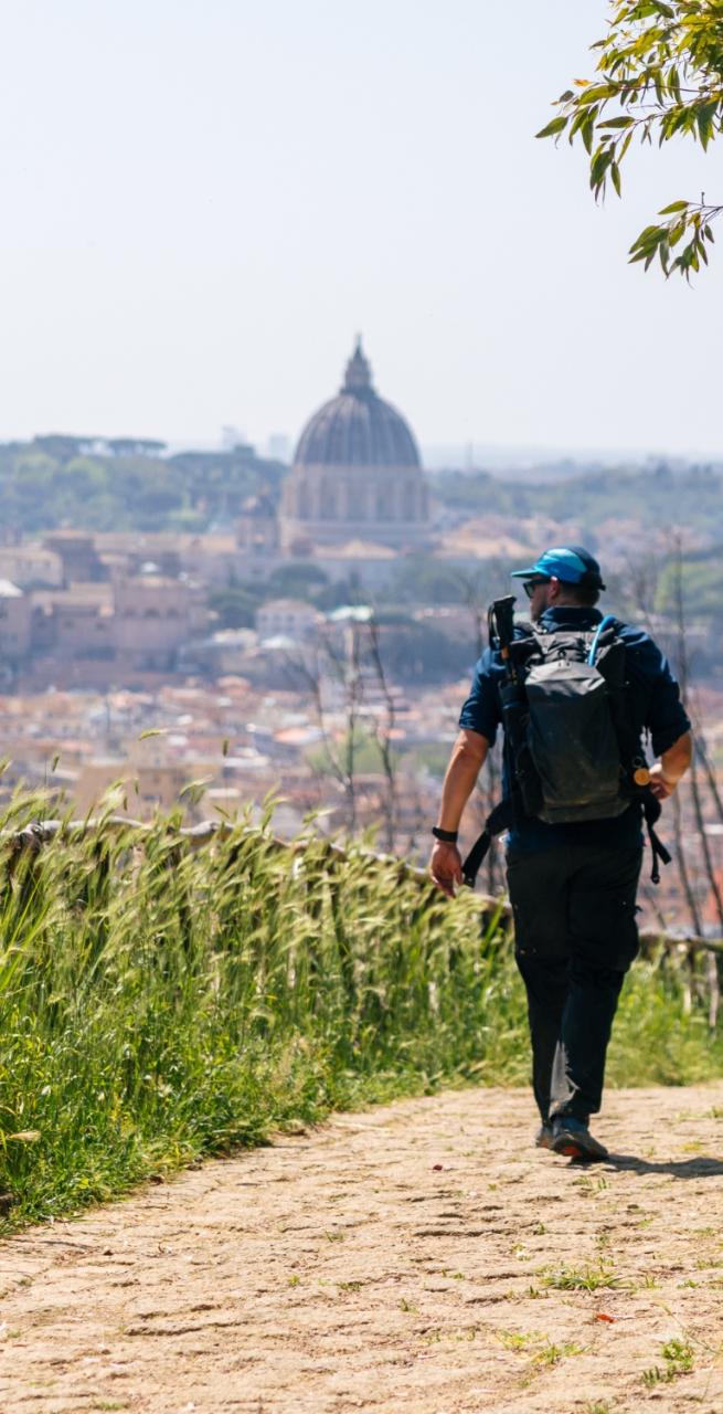 Walkers along the via francigena last 100 km on a rural path surrounded by flower fields