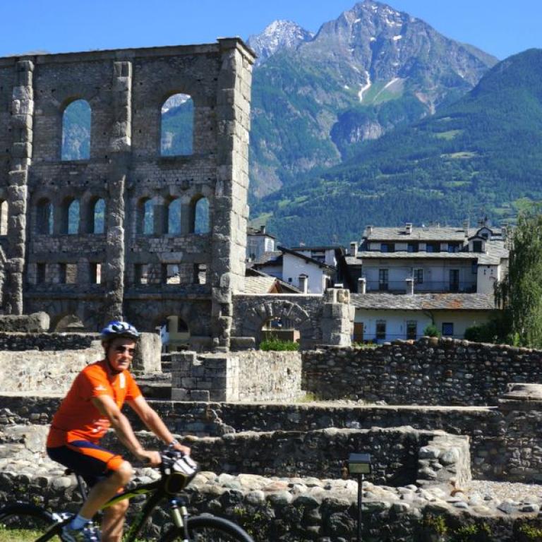 man cycling in Aosta near the Roman scaves
