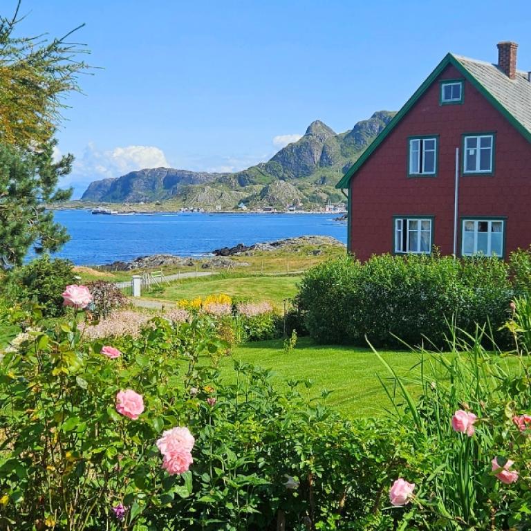 Casa tradizionale norvegese con giardino affacciata sul mare lungo il Cammino Costiero di Sant’Olav