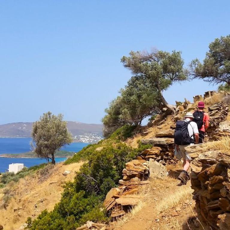 Hikers walking along coastal paths between Andros and Tinos