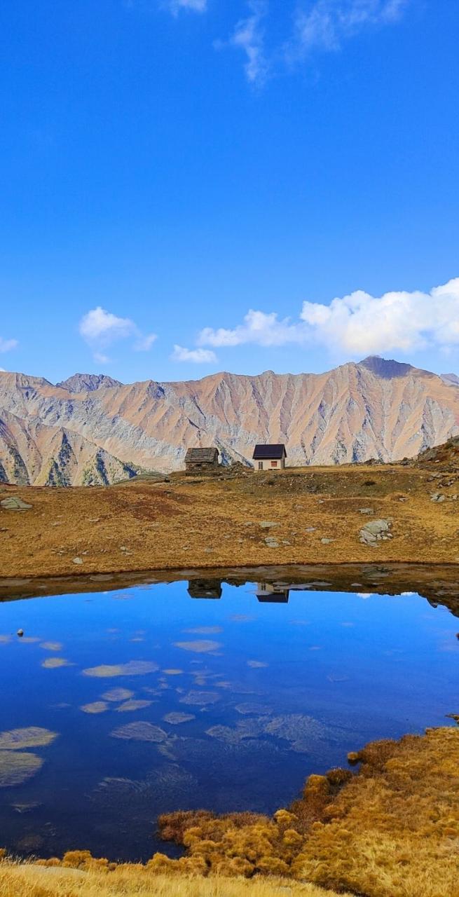 Alpine lake reflecting rugged mountain peaks along the Piedmont alpine walking tour