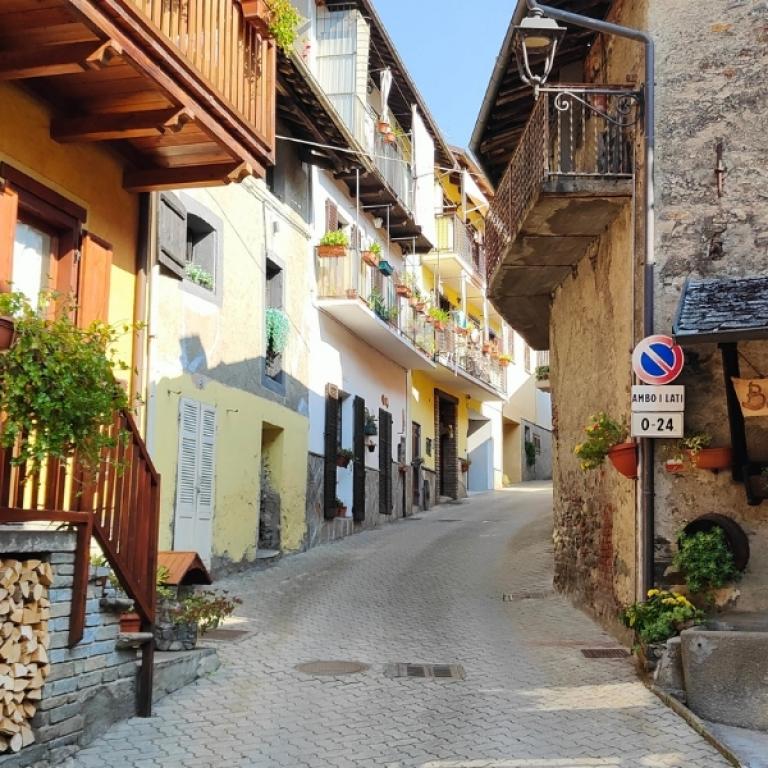 Traditional alpine village with stone houses and wooden balconies along the Piedmont alpine walking tour